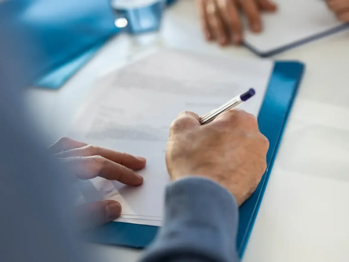 mężczyzna podpisujący dokument